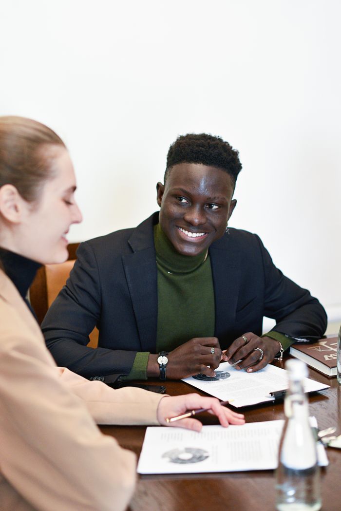 Two business partners engaged in a lively discussion during a meeting in a modern office.